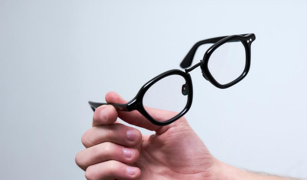 AKILA eyeglasses held by a hand