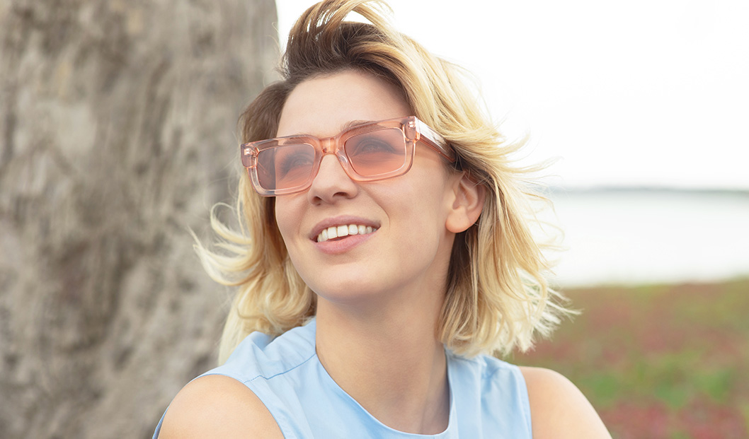 Young woman by a lake wearing CHIMI sunglasses | Mia Burton Magazine